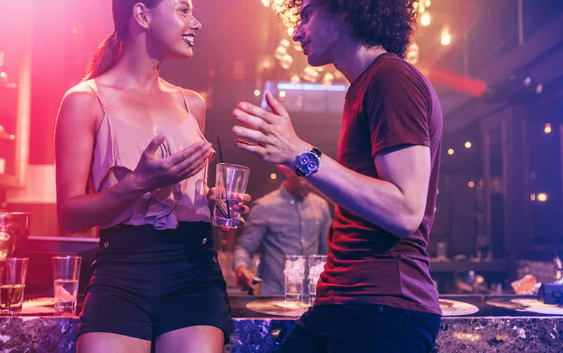 bel homme parler à une femme en discothèque