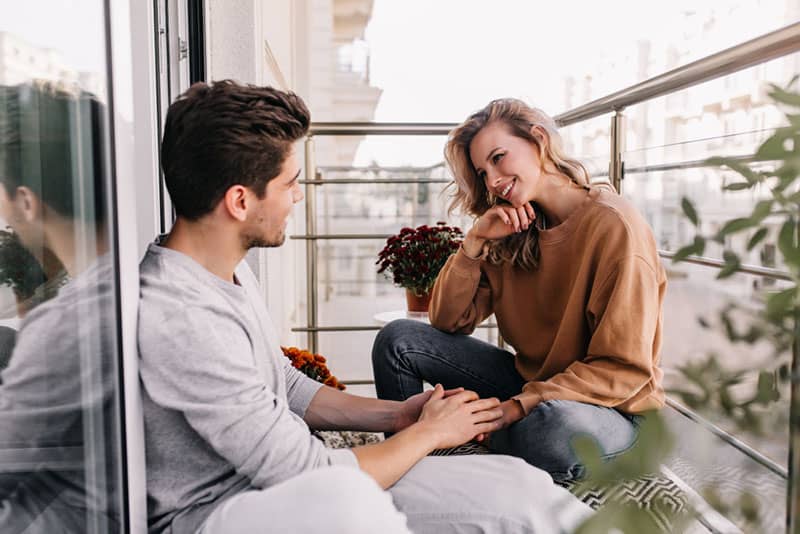 couple heureux parler sur balcon