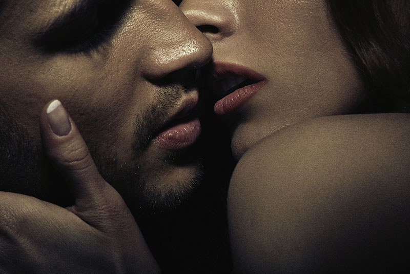 couple sensuel s'embrassant dans l'obscurité