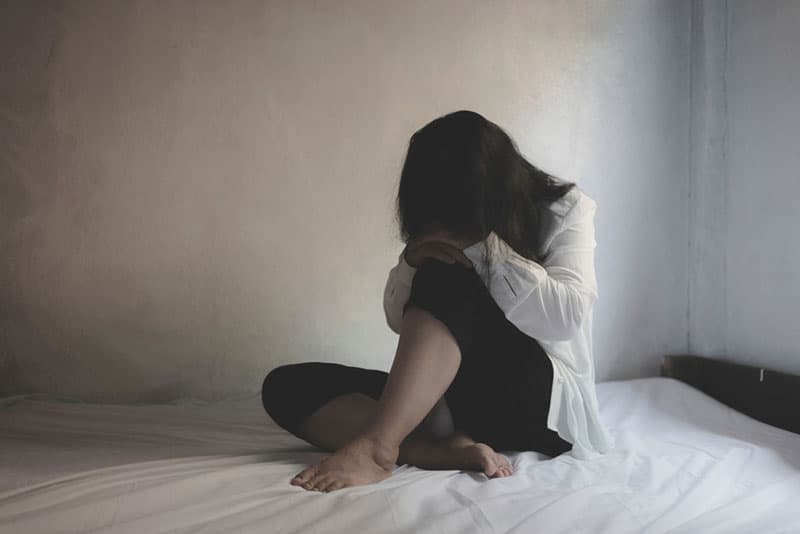 femme déprimée solitaire sur lit