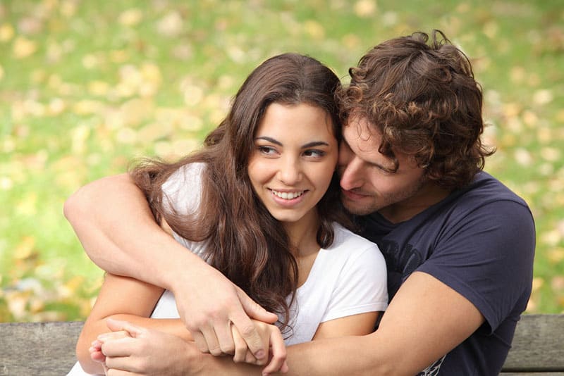 jeune couple, étreindre, banc, dans parc