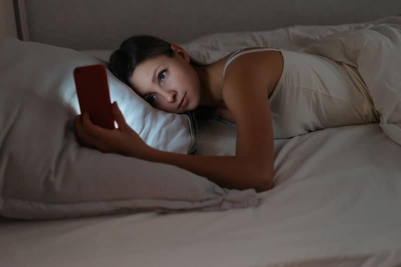 jeune femme, téléphone, dans lit