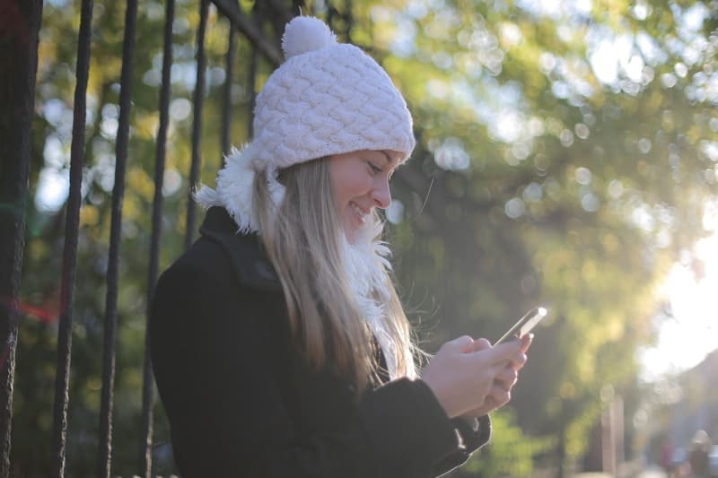 la femme tient le téléphone et écrit