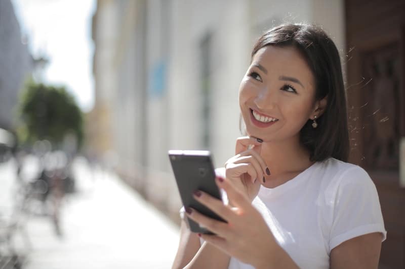 une femme pensive regarde le téléphone
