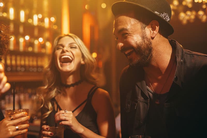 homme et femme riant dans un bar