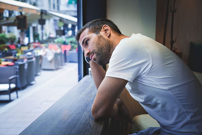 homme triste près de la fenêtre