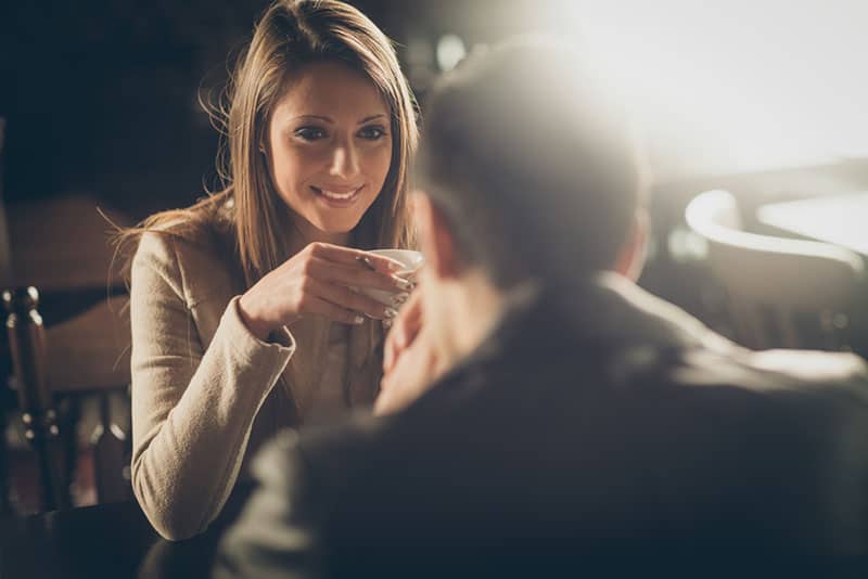 jeune couple, conversation, à, a, tasse café, dans, elles, mains