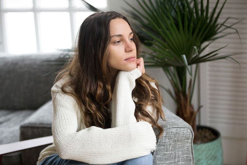 jeune femme assise sur un canapé dans le salon