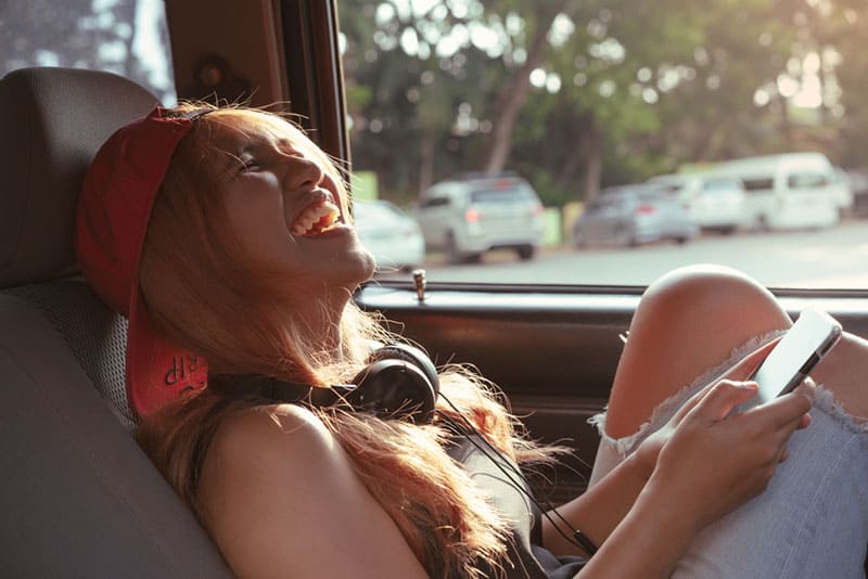jeune femme, rire, dans voiture