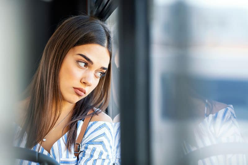 triste jeune femme par fenêtre en bus