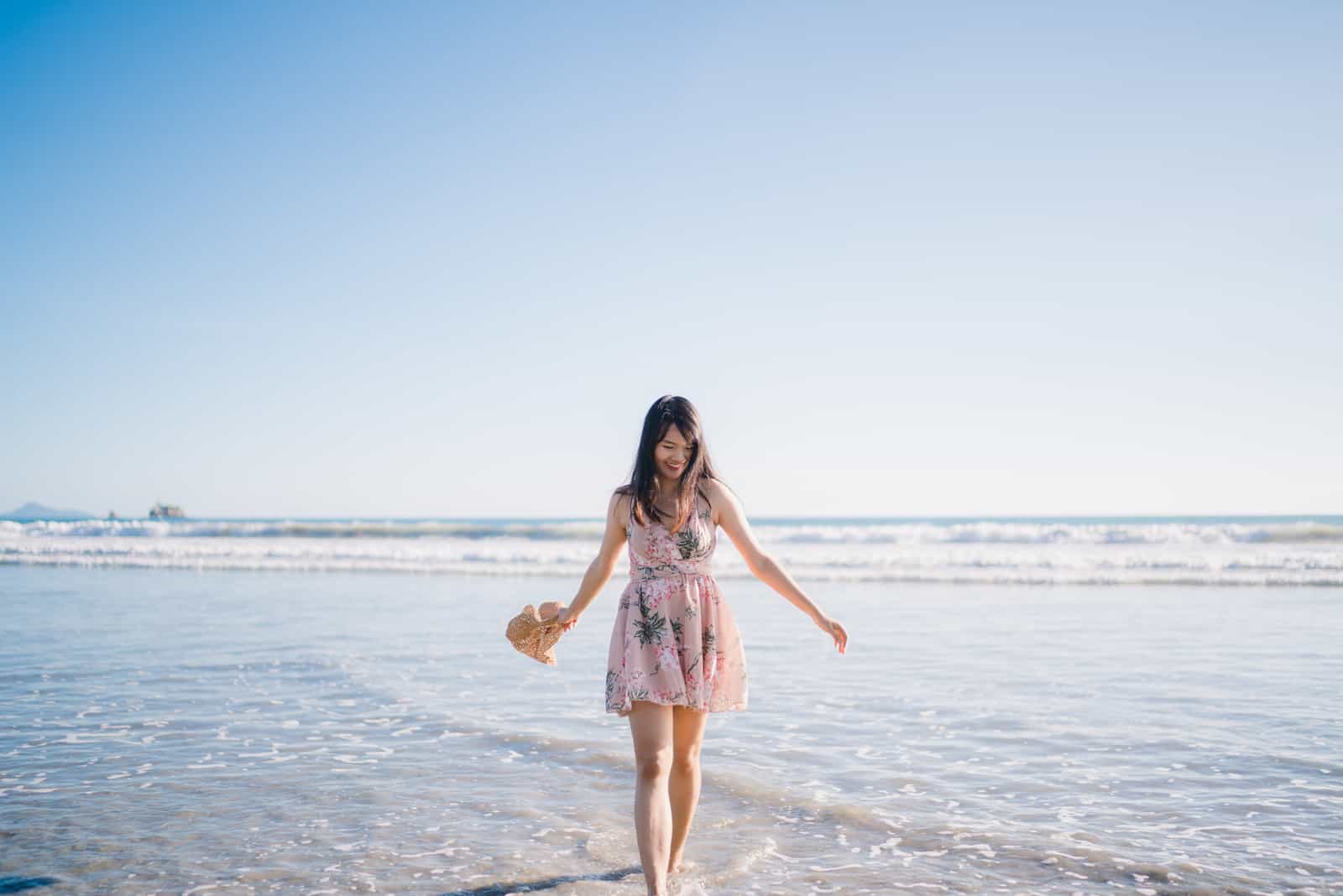 une belle femme aux longs cheveux noirs se pose sur la plage