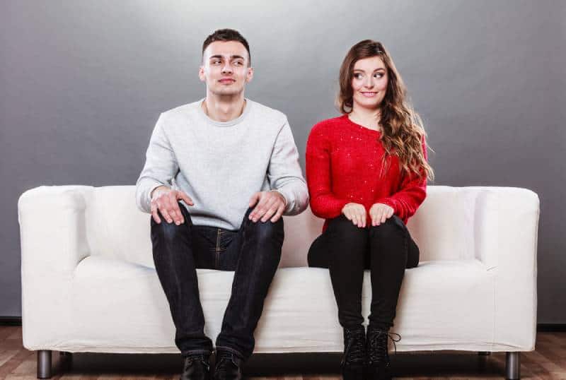 couples s’asseyant sur le divan, visage confus
