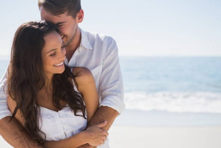 Un couple séduisant se câline sur la plage