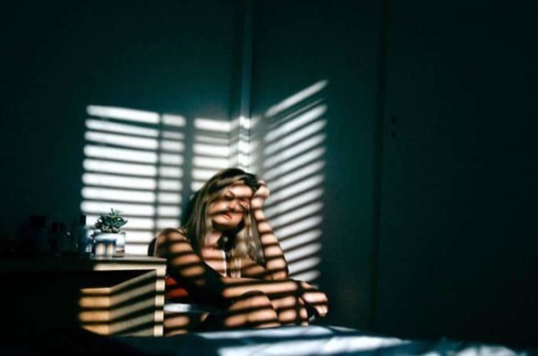 une femme triste dans une piece sombre