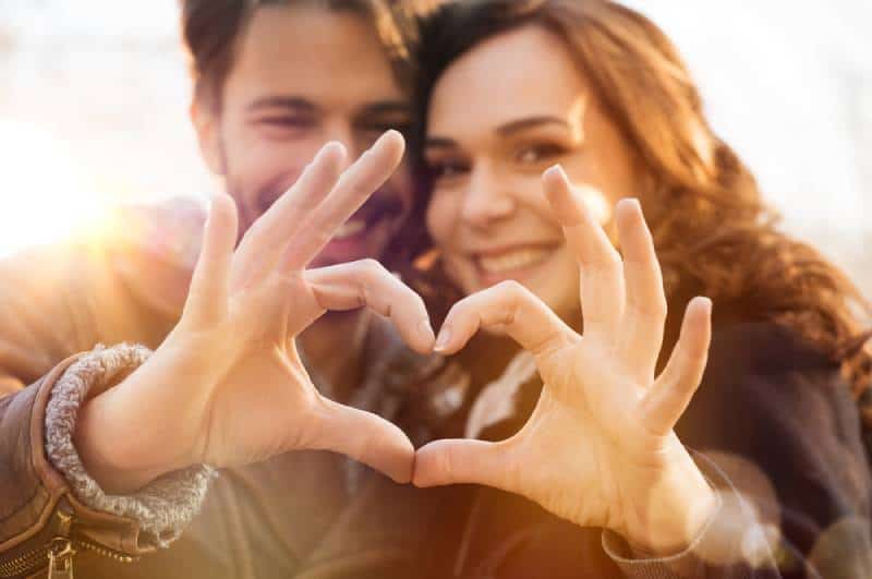 Gros plan d'un couple en forme de cœur avec les mains