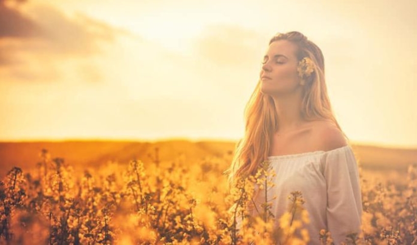 femme blonde aux yeux fermes dans le champ de fleurs