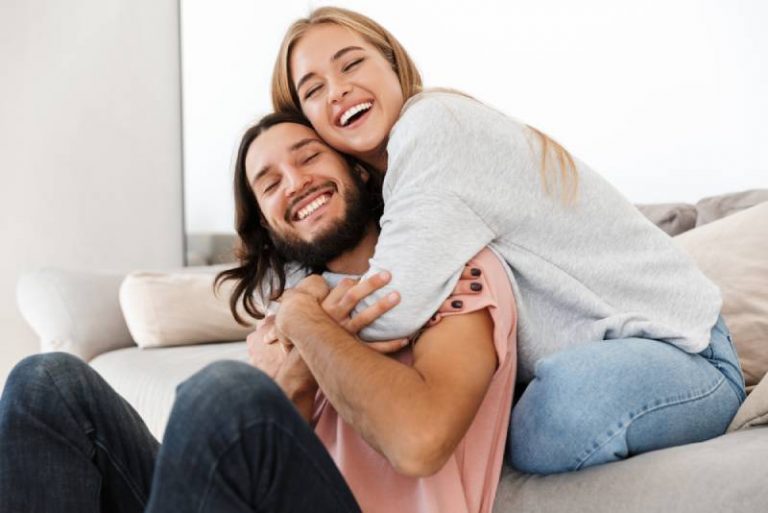 jeune couple d'amoureux sur un canapé qui s'embrasse