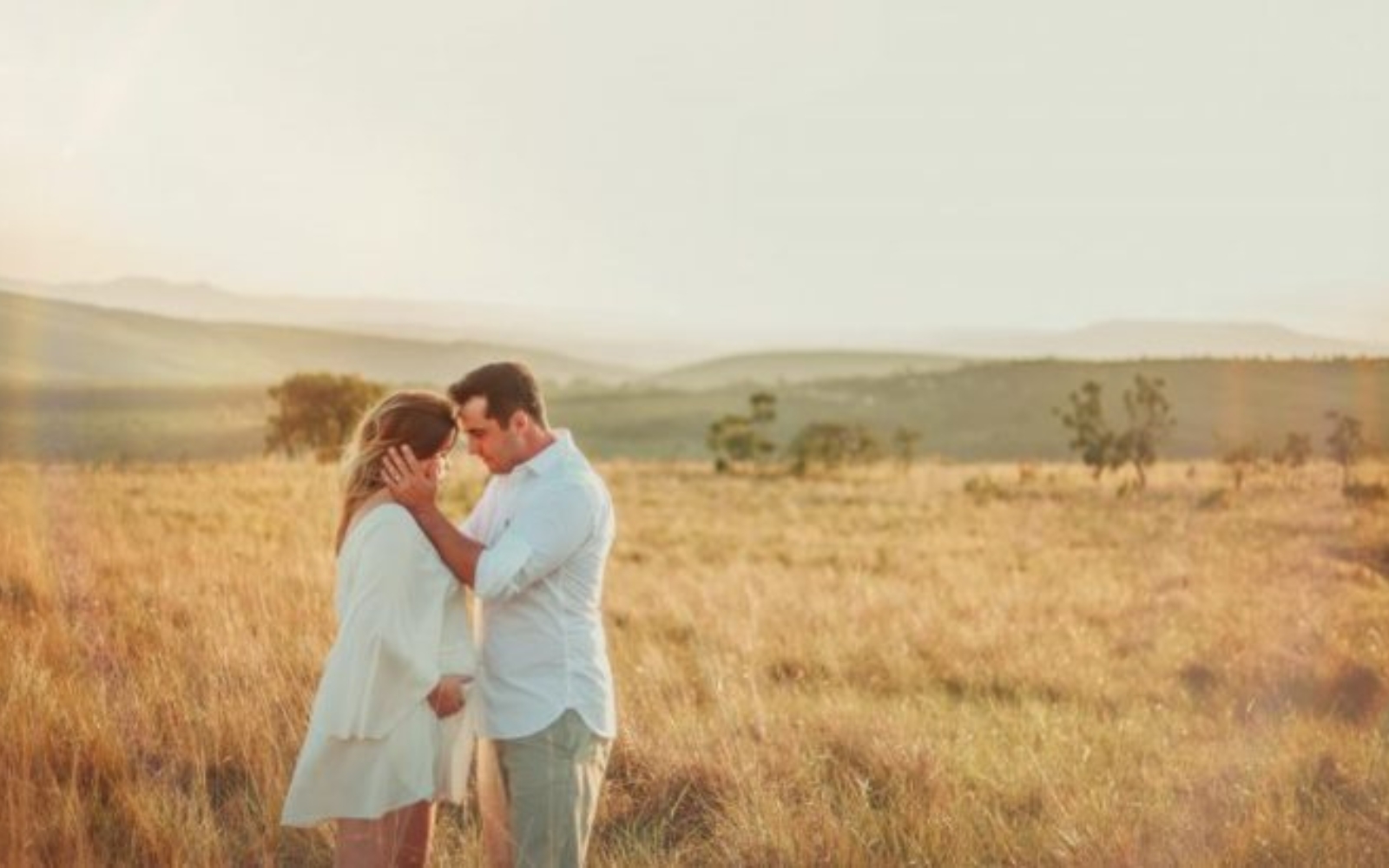 un homme et une femme embrassant dans un champ