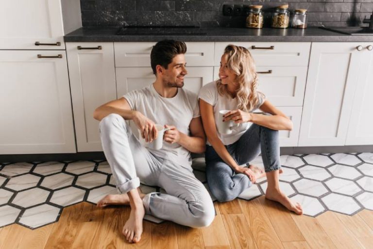 couple heureux assis par terre dans la cuisine