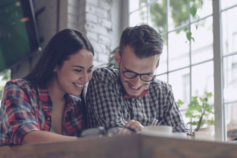 Un jeune couple souriant à l'intérieur