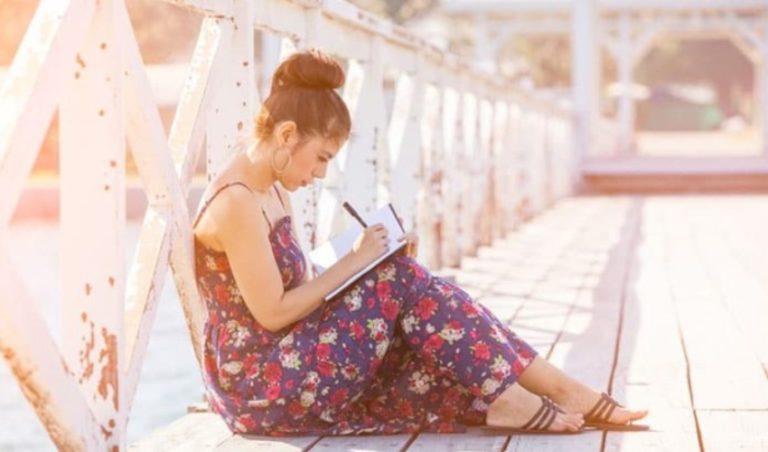femme ecrivant une lettre sur le pont