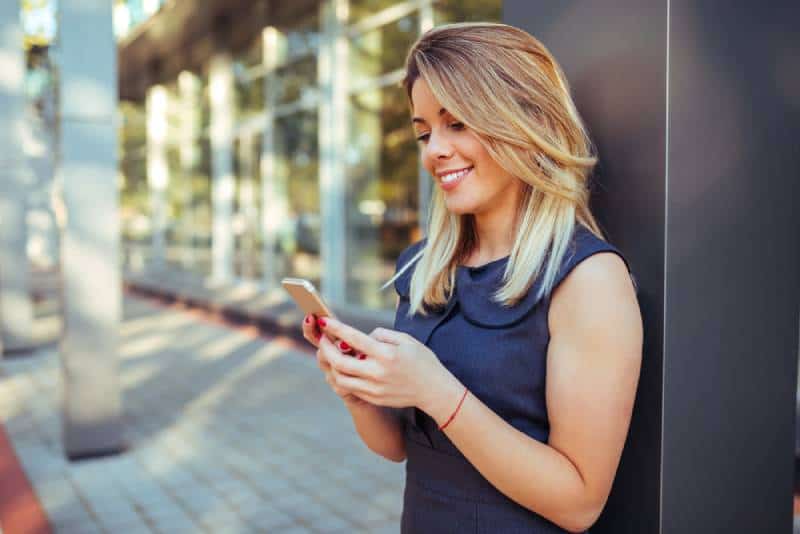 Une belle femme envoie des SMS sur son téléphone portable