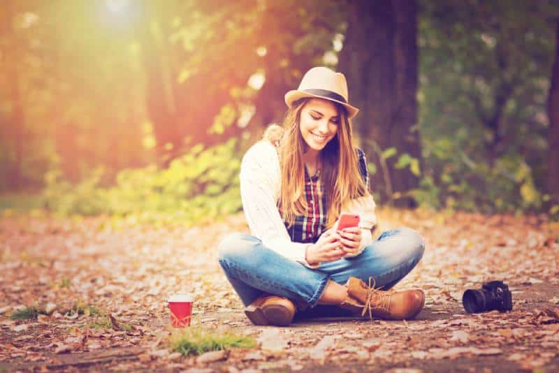Une jeune adolescente à la mode avec un smartphon