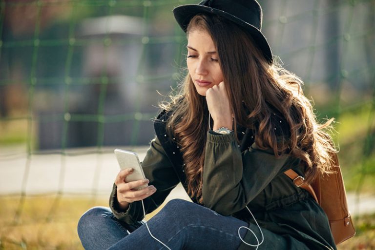 femme inquiète regardant téléphone mobile