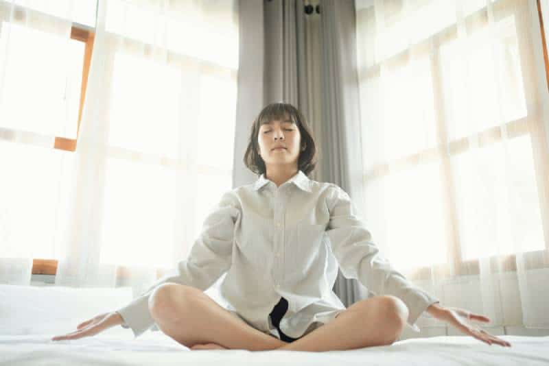 belle femme se réveille et pratique la méditation d'entraînement