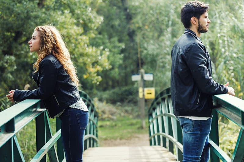 couple debout sur le pont en face