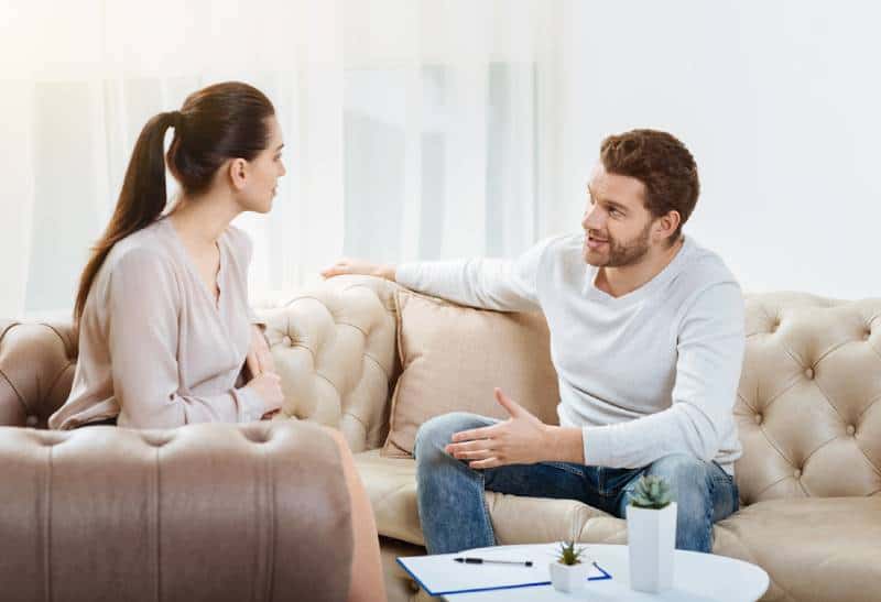 couples parlant et s’asseyant sur le sofa