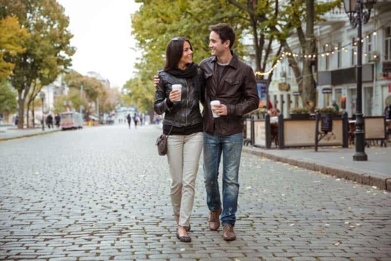 couples étreignant marchant avec un café