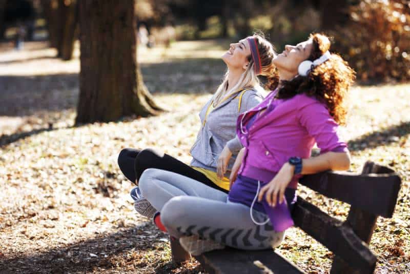 des femmes assises sur un banc au parc et écoutant de la musique