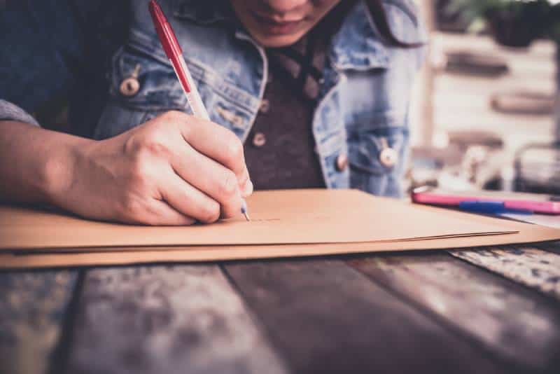 femme écrivant une lettre sur une table en bois