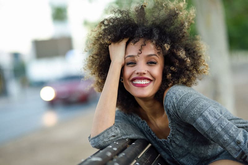 femme afro bouclée souriant