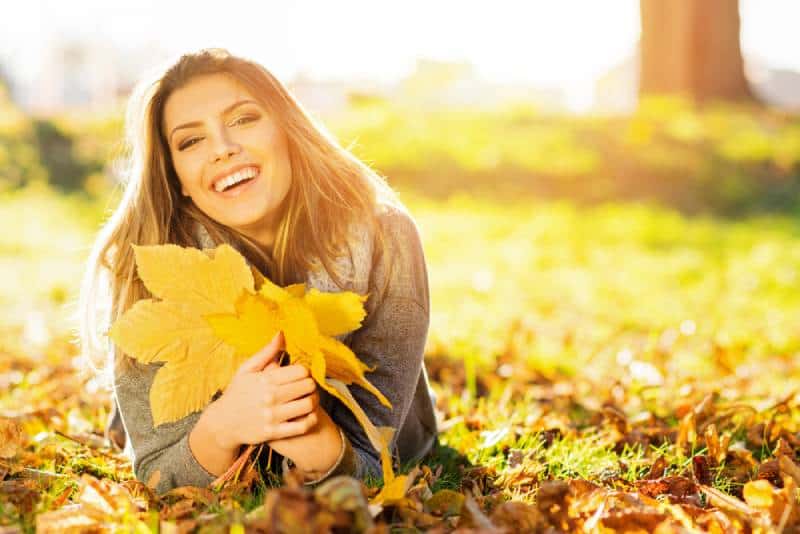 femme se trouvant sur l’herbe en automne