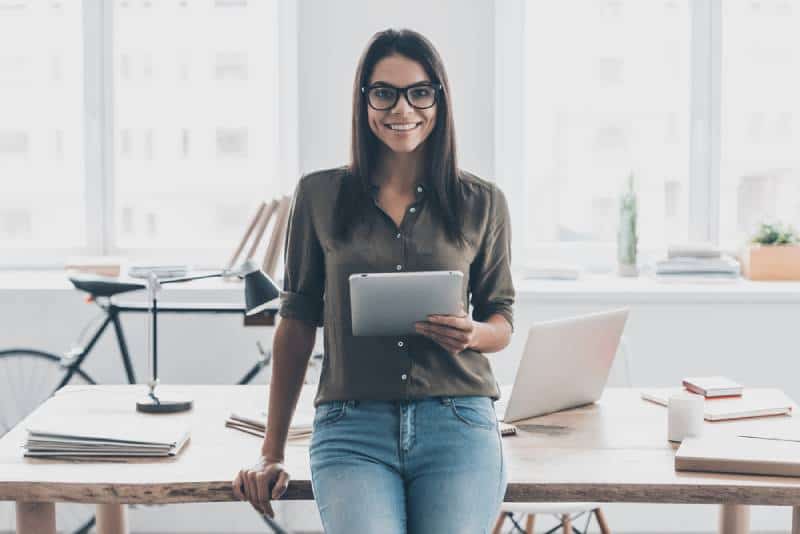 femme souriante allongée au bureau de travail