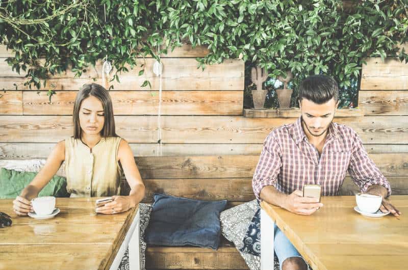 homme et femme ignorant l’un l’autre au café
