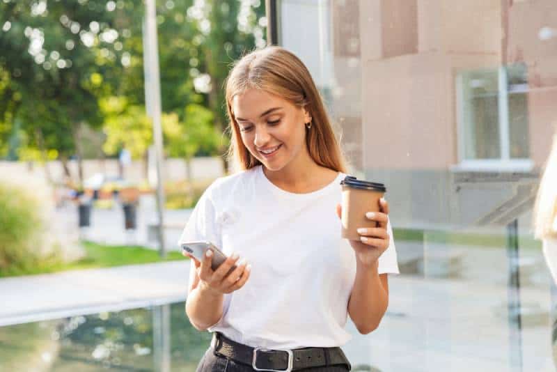 jeune fille tapant sur son téléphone à l'extérieur
