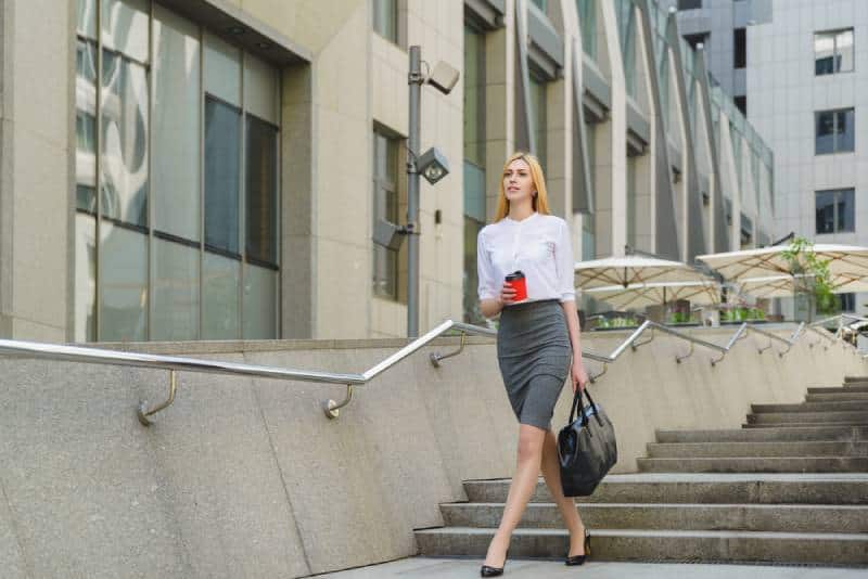 marchant à l’extérieur de la femme de confiance en soi avec la tenue de bussines
