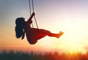 silhouette de jeune fille sur balançoire