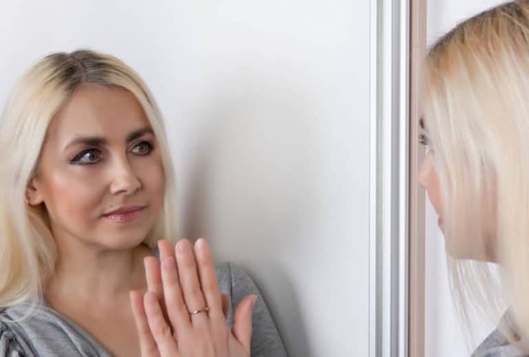 une femme inquiète est observée dans le miroir