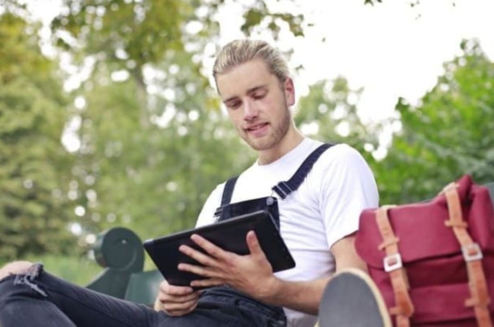 un homme bleu est assis avec une tablette a la main