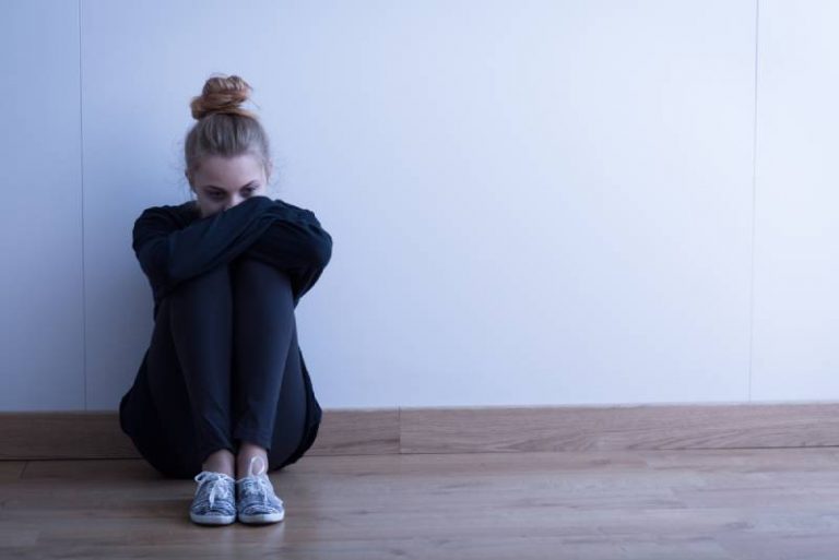 Une femme triste et dépressive assise sur le sol