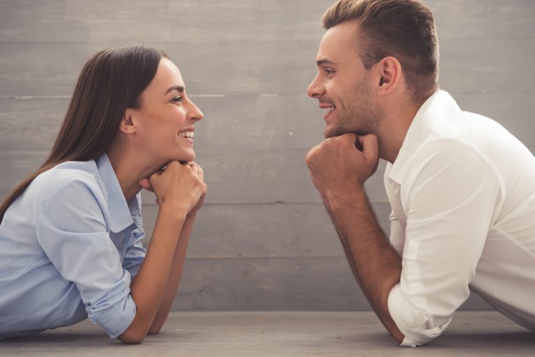 couple se regardant et s'appuyant sur leurs mains