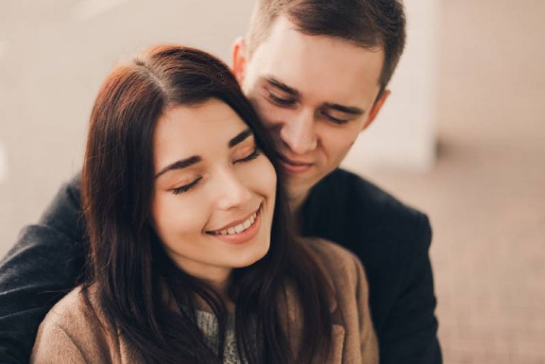 Un couple d'amoureux s'embrasse dans la rue.