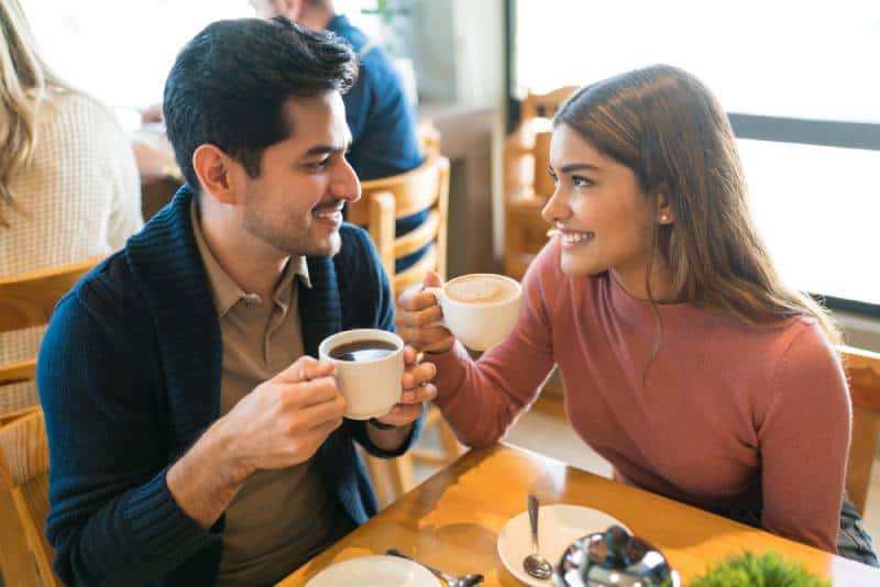 Des jeunes amoureux apprécient le café tout en se regardant dans un café