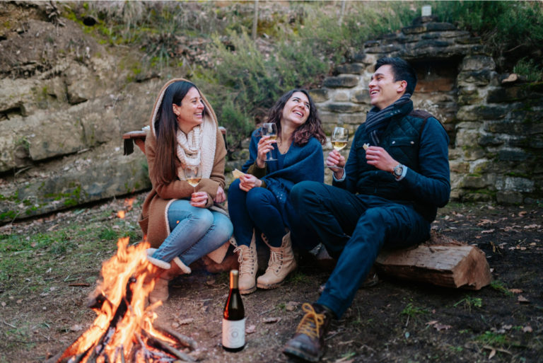 des amis s'assoient près du feu et parlent