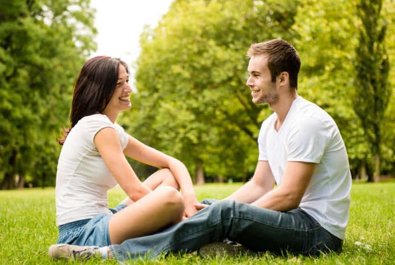 Jeune couple heureux discutant ensemble en plein air
