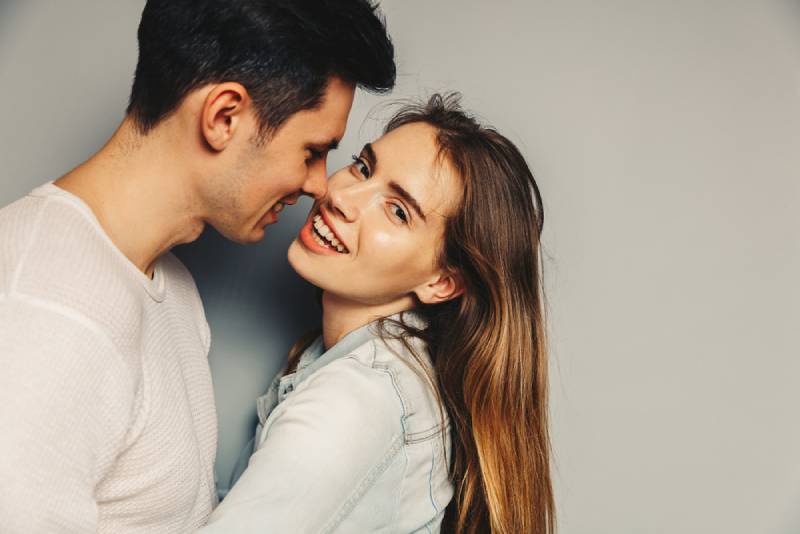 Portrait d'un beau jeune couple en tenue décontractée, s'étreignant et souriant